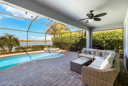 Integrated pool / hot tub with a sunroom, an outdoor lounge area, glass enclosure, a patio area, and a water view