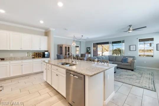 Kitchen featuring white cabinetry, stainless steel dishwasher, a ceiling fan, hanging light fixtures, and light stone counters