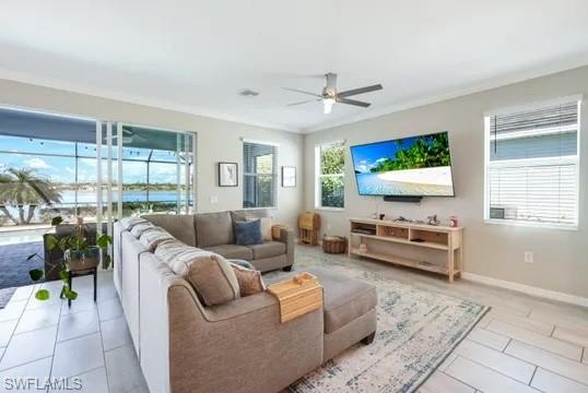 Tiled living area with a ceiling fan and ornamental molding