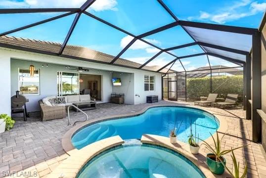 Integrated pool / hot tub featuring a sunroom, an outdoor hangout area, a patio, and a lanai