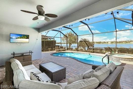 Combined pool / hot tub with an outdoor hangout area, a sunroom, a patio area, glass enclosure, and a water view