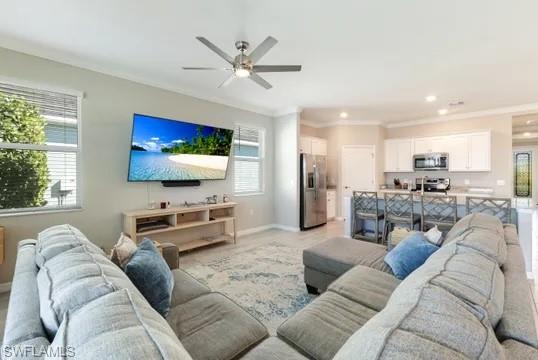 Living room featuring ornamental molding and a ceiling fan