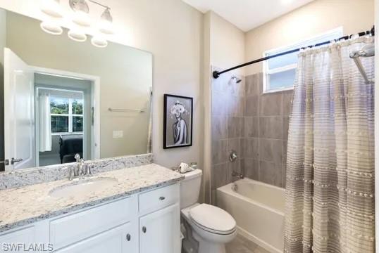Bathroom with healthy amount of natural light, shower / tub combo, and vanity