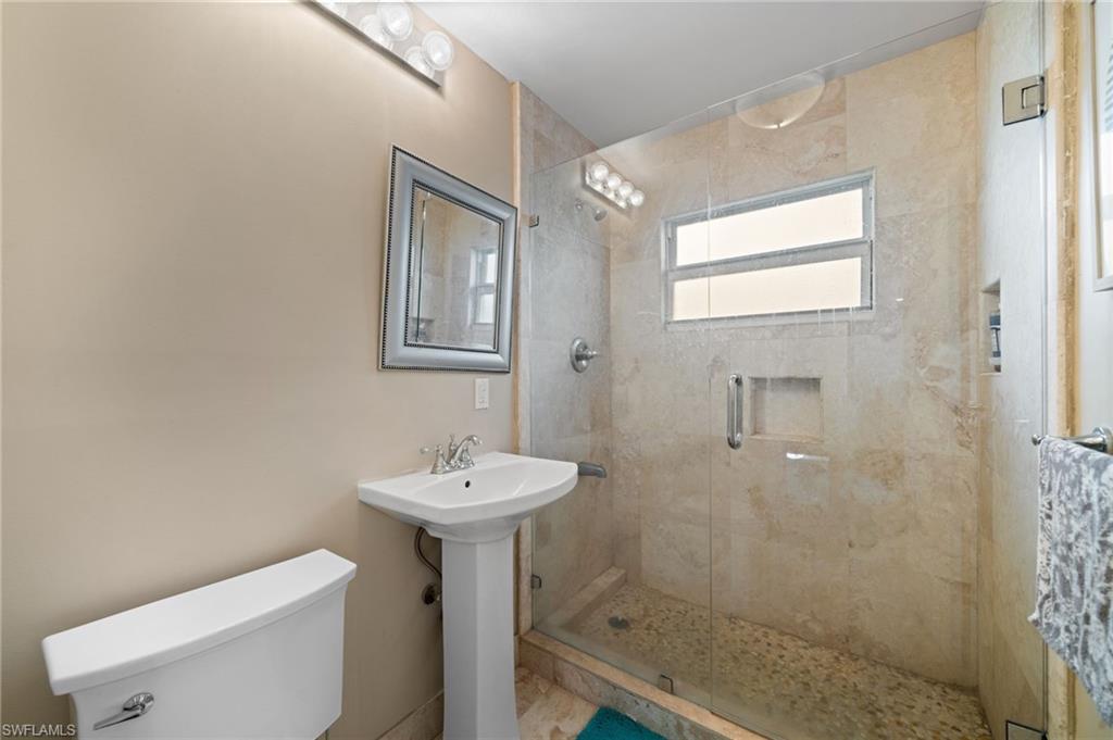 Bathroom featuring toilet and a shower with shower door