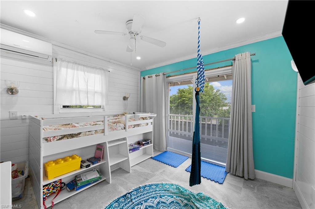 Bedroom featuring crown molding, ceiling fan, a wall mounted air conditioner, and access to outside