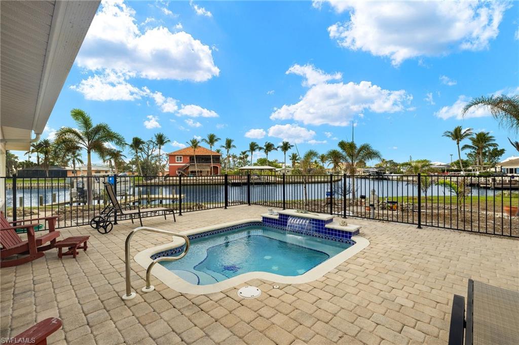 View of swimming pool featuring a patio area, a water view, and a community hot tub virtually enhanced images