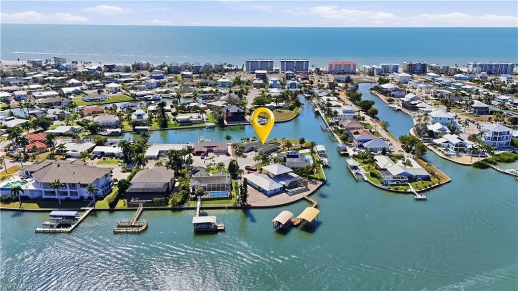 Aerial view of property and surrounding area with a large body of water and nearby suburban area - Virtually Edited Image