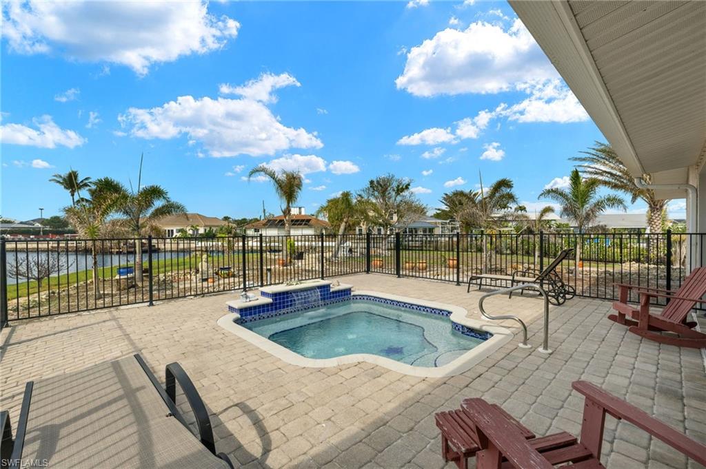 View of swimming pool with a hot tub, a patio, and a water view virtually enhanced images