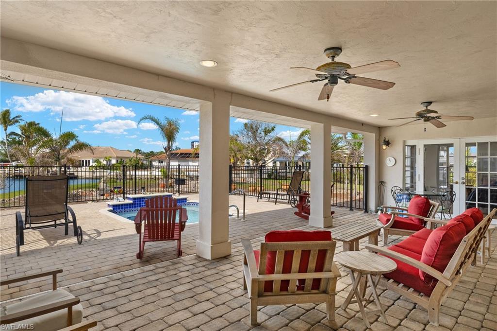 View of patio / terrace with ceiling fan, french doors, and a fenced in pool virtually enhanced images
