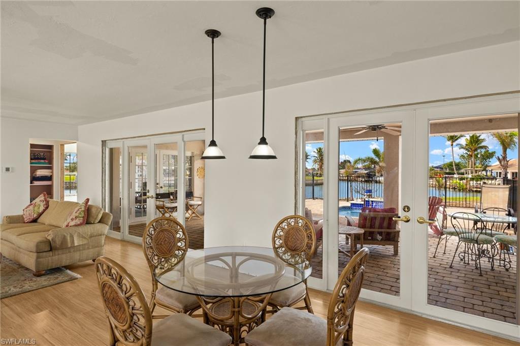 Dining room featuring a water view, light wood-type flooring, and french doors