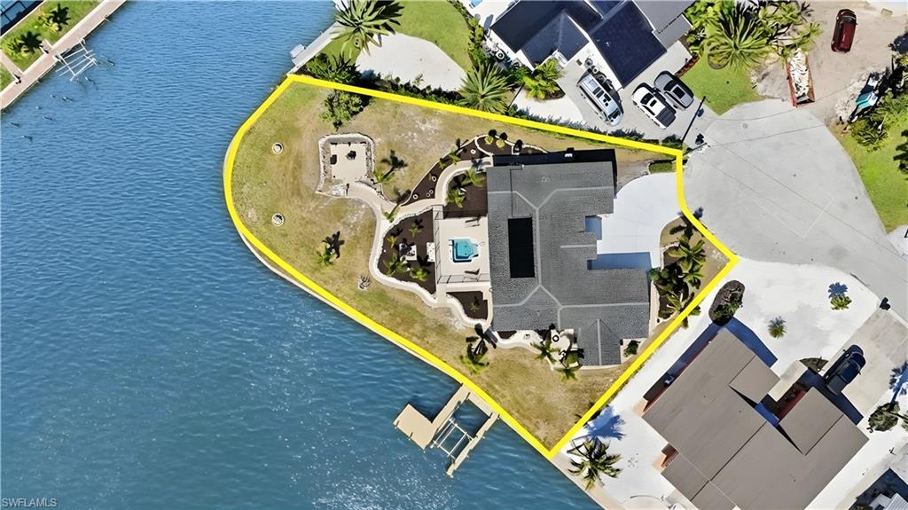 Aerial view of property and surrounding area featuring property parcel outlined and a large body of water - Virtually Edited Image
