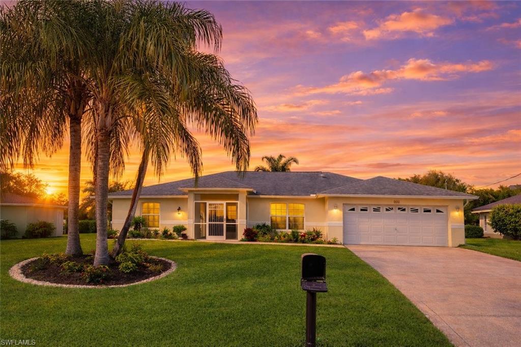 Single story home with a front lawn, concrete driveway, stucco siding, and an attached garage