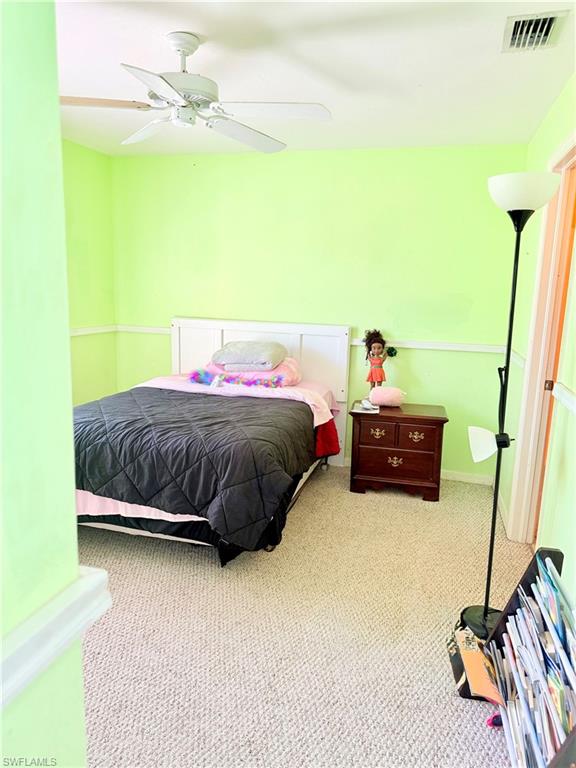 Carpeted bedroom featuring a ceiling fan and baseboards