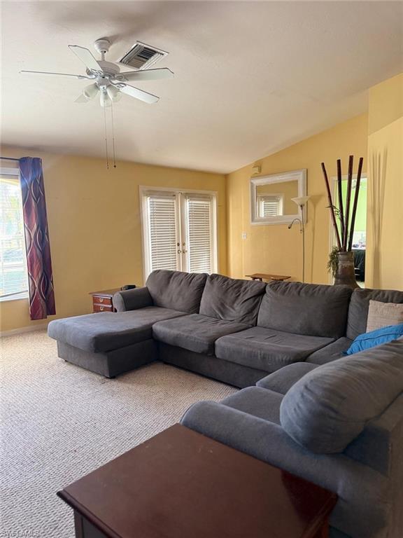 Carpeted living room featuring a ceiling fan