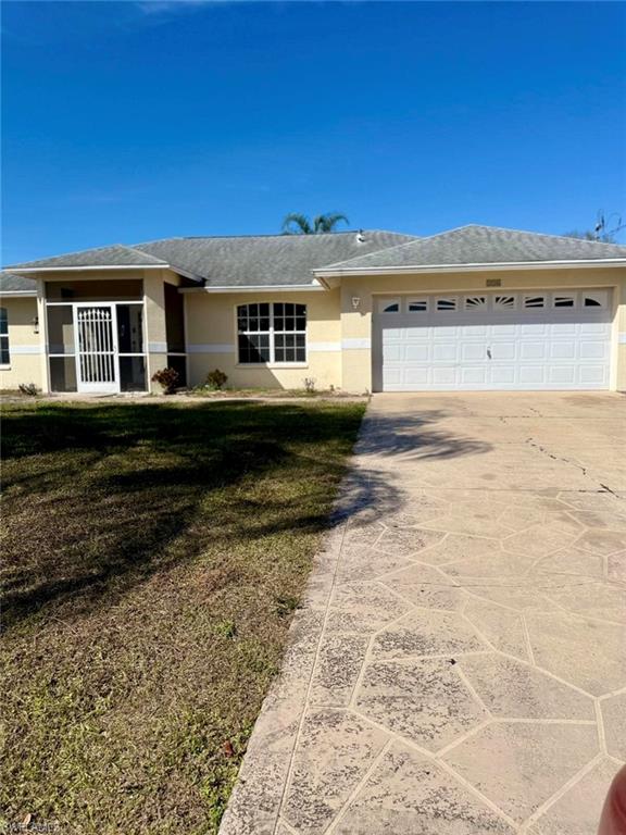 Single story home featuring driveway, a garage, stucco siding, and a front yard
