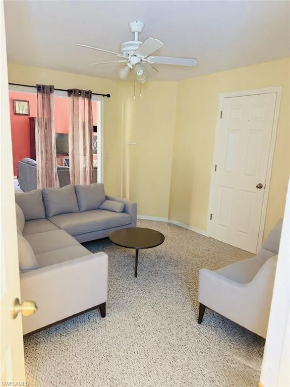 Living area with ceiling fan and baseboards