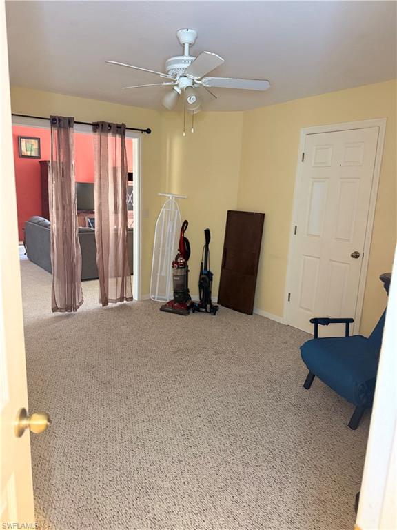Unfurnished room featuring ceiling fan and carpet flooring