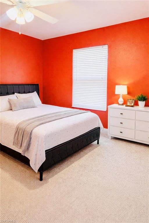 Bedroom with a ceiling fan and light carpet