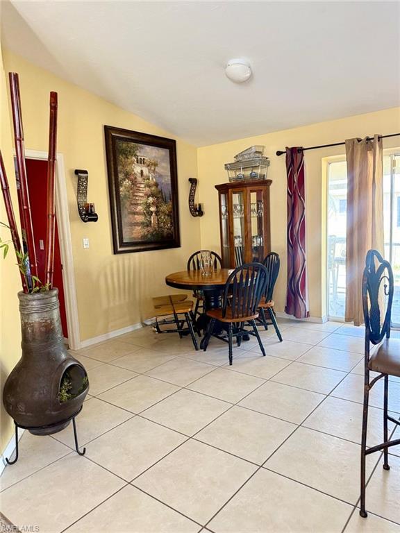 Dining space with light tile patterned floors and baseboards