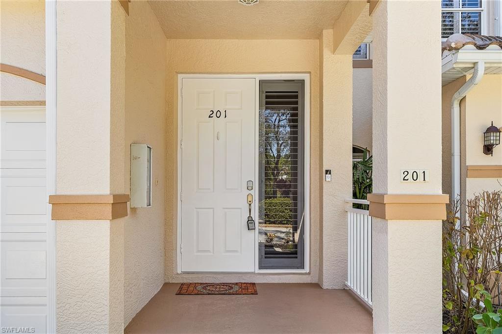 Doorway to property featuring stucco siding and covered porch