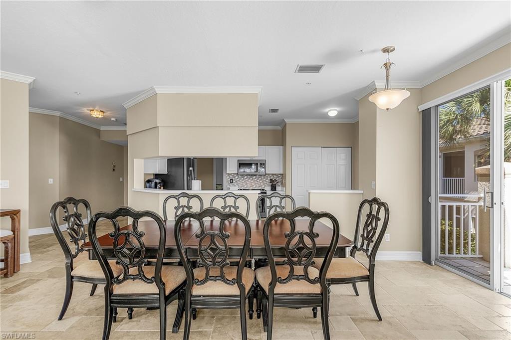 Dining room with ornamental molding and light stone finish flooring