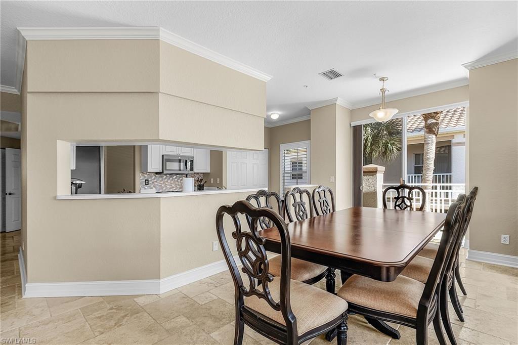 Dining room featuring crown molding and stone tile floors