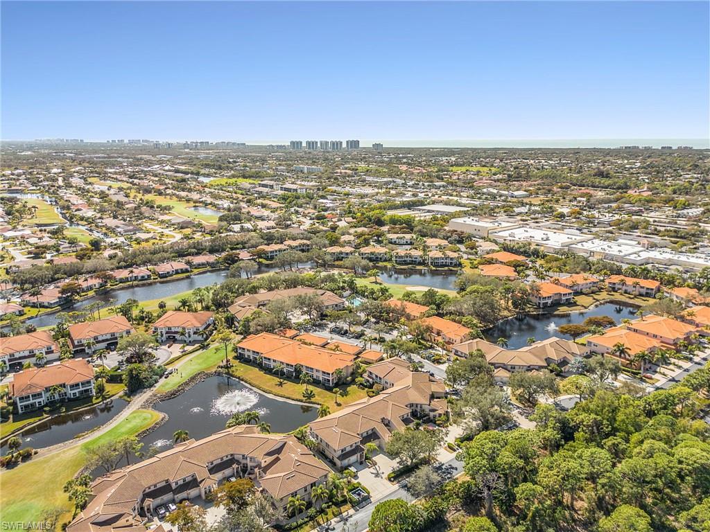 Aerial view of property's location featuring a nearby body of water and nearby suburban area