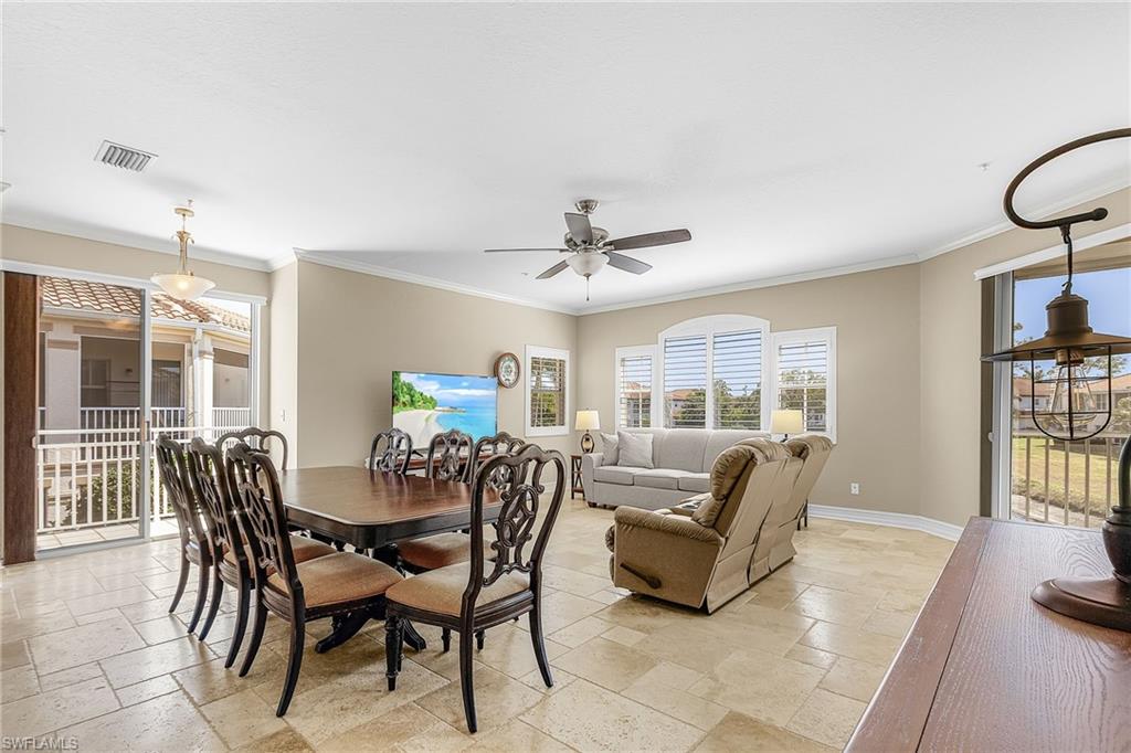Dining space with stone tile floors, ceiling fan, and crown molding