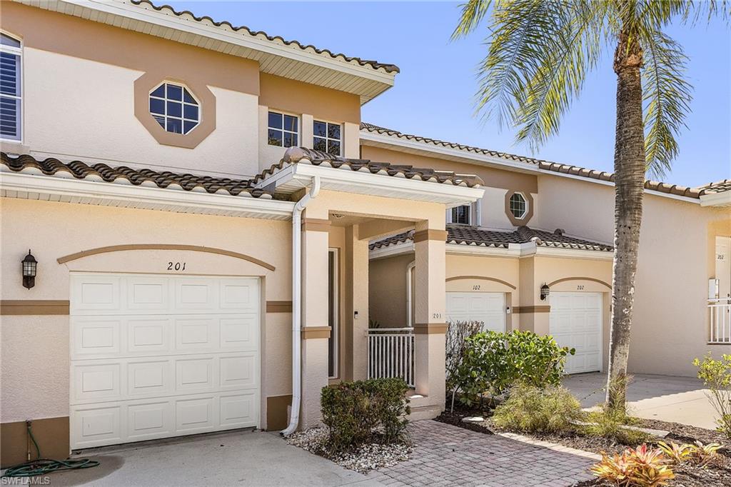 Mediterranean / spanish house with stucco siding, a garage, a tiled roof, and driveway