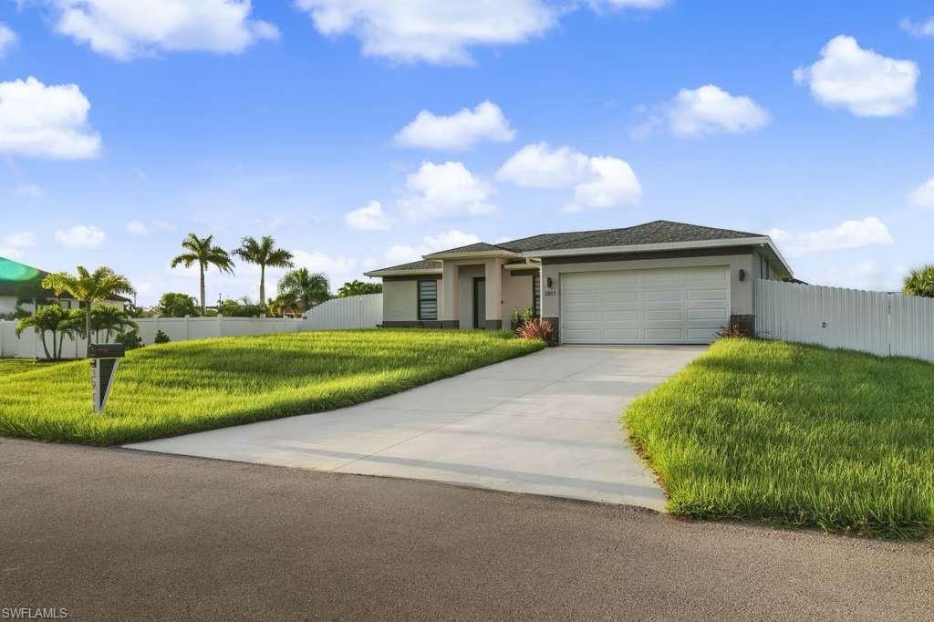 Ranch-style house with stucco siding, driveway, and a garage