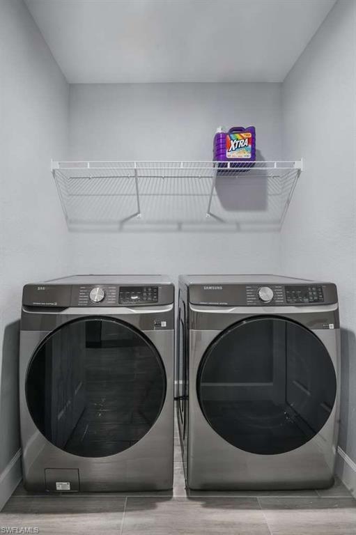 Laundry area with baseboards and washer and dryer