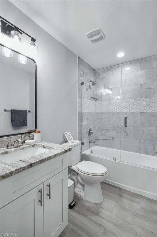 Full bathroom featuring combined bath / shower with glass door and vanity