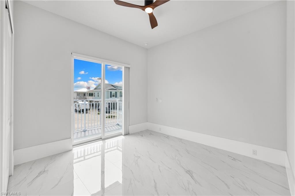 Empty room with light marble finish flooring and a ceiling fan