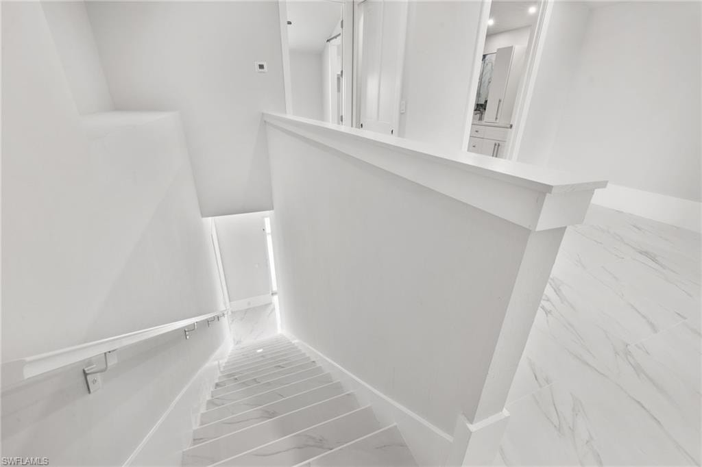 Stairway featuring marble finish floors and baseboards