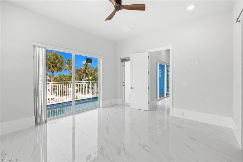 Empty room with ceiling fan, recessed lighting, and light marble finish flooring