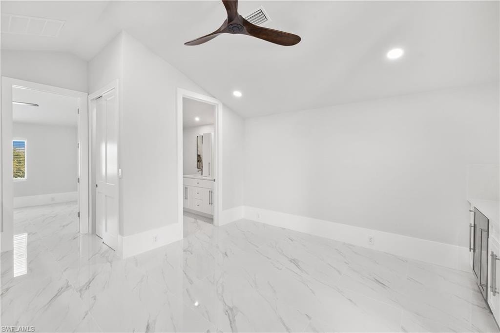 Spare room featuring ceiling fan, light marble finish flooring, recessed lighting, and vaulted ceiling