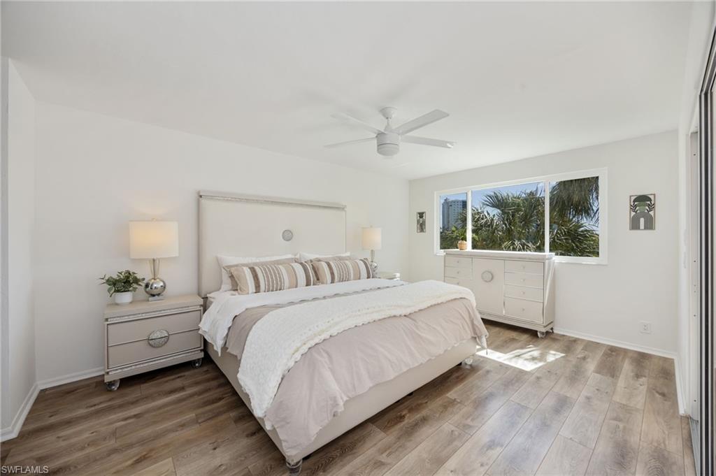 Primary Bedroom enjoys views to the lanai, lake & Wiggins Bay
