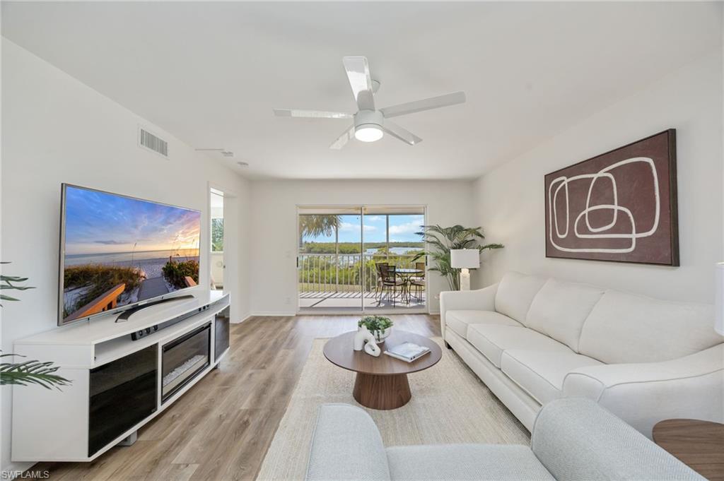 Living room with ceiling fan and light wood-style floors