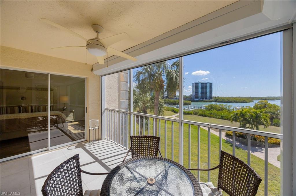 Sunroom featuring a balcony, a ceiling fan, a water view, and outdoor dining area