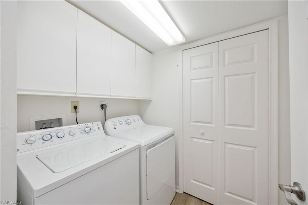 Laundry room with washer and dryer, closet, and cabinet space