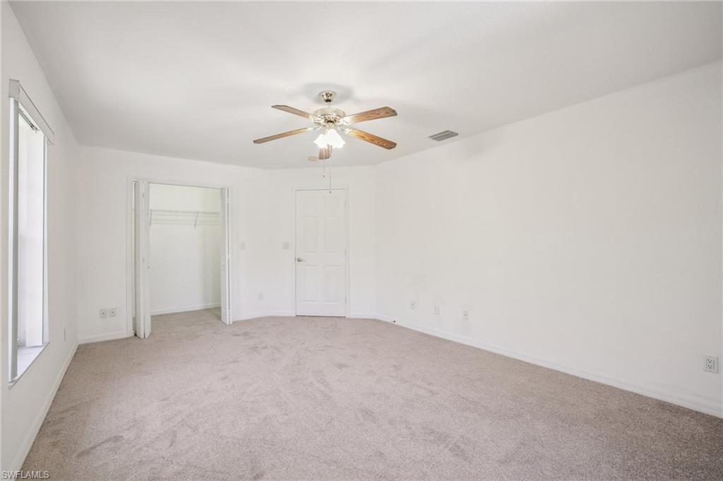 Other view of bedroom 2 with light carpet, a ceiling fan, and a closet