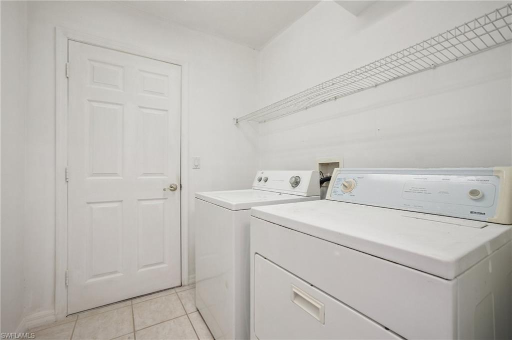 Laundry room with independent washer and dryer, and light tile patterned floors