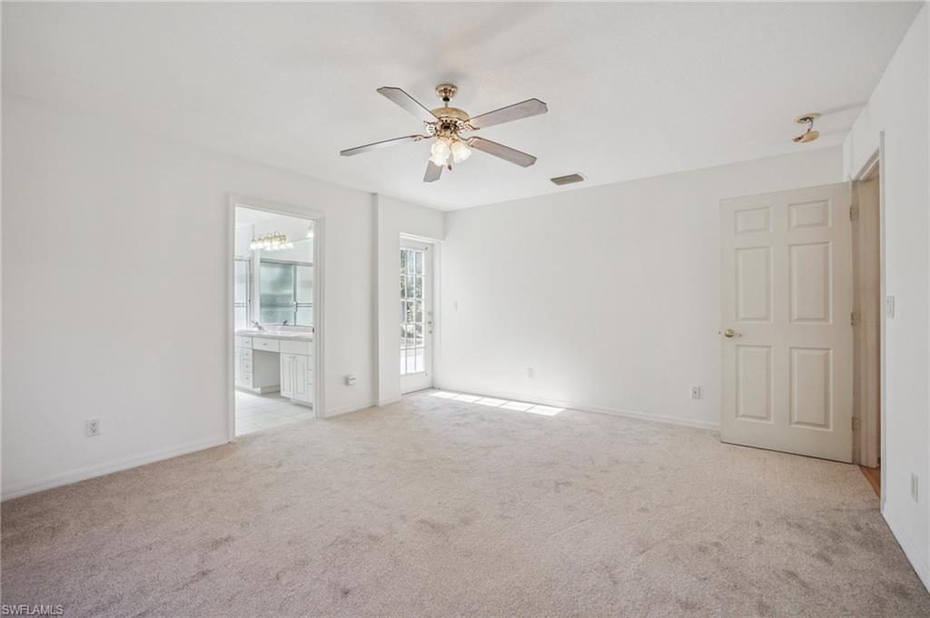 Primary bedroom featuring a ceiling fan, light-colored carpet and with access to outside.
