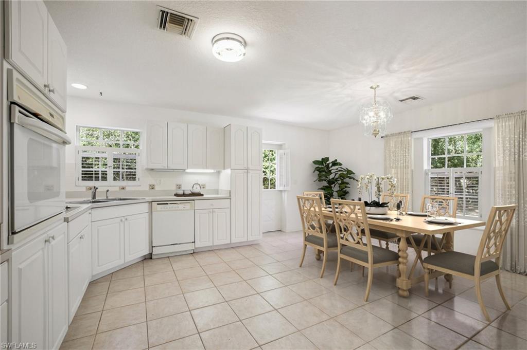 Virtually Staged Dining room featuring healthy amount of natural light, light tile patterned floors, and a chandelier