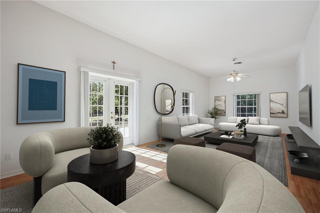 VIRTUALLY Staged Living room with wood laminate floors, French doors, and healthy amount of natural light