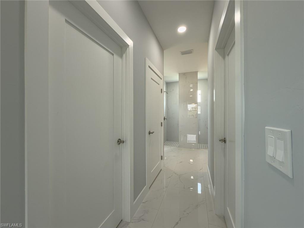 Hall featuring marble finish floor, visible vents, and baseboards