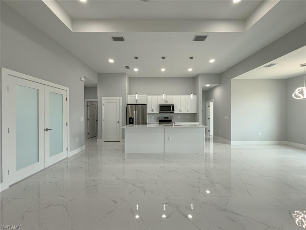 Unfurnished living room with baseboards, visible vents, and recessed lighting