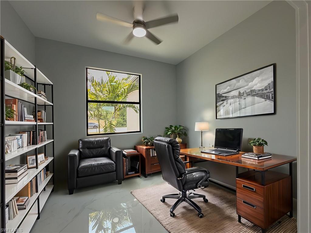 Office space with a ceiling fan and marble finish floor