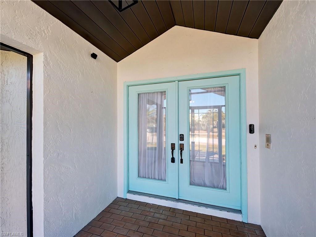 Doorway to property featuring french doors, stucco siding, and a patio
