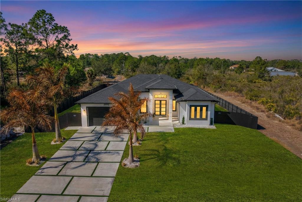 View of front facade featuring concrete driveway, stucco siding, french doors, and a garage